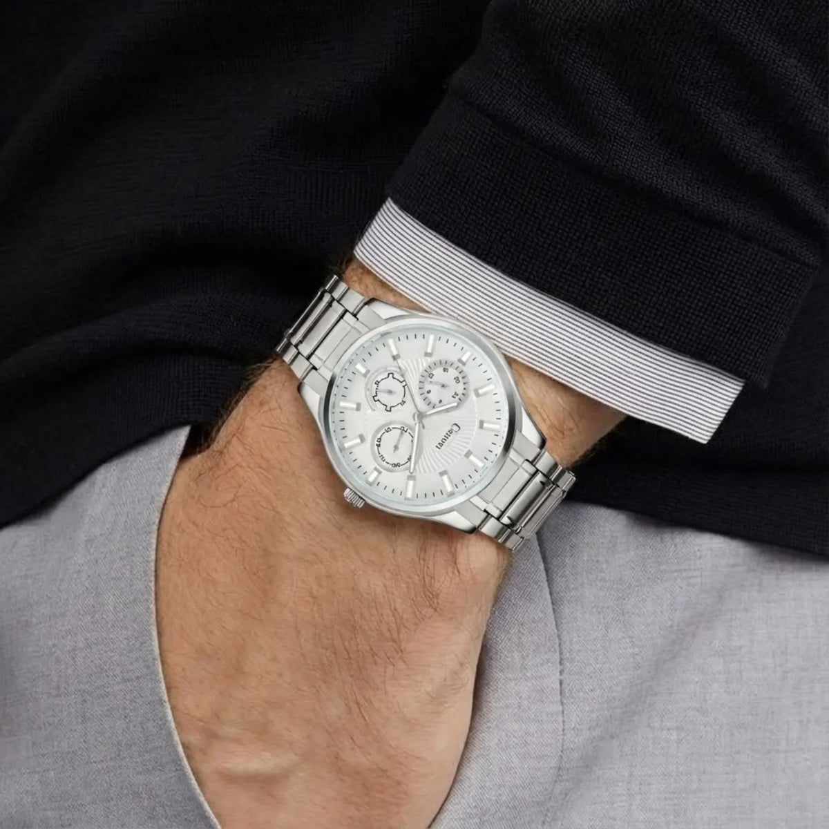 Silver analog men's wristwatch with multi-dial face, worn on wrist, dress shirt and pants