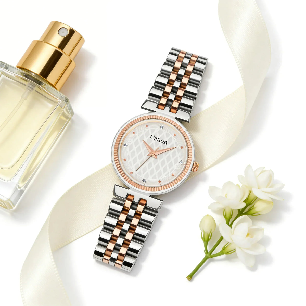 Elegant two-tone women's analog wristwatch with floral accents, perfume bottle, and ribbon