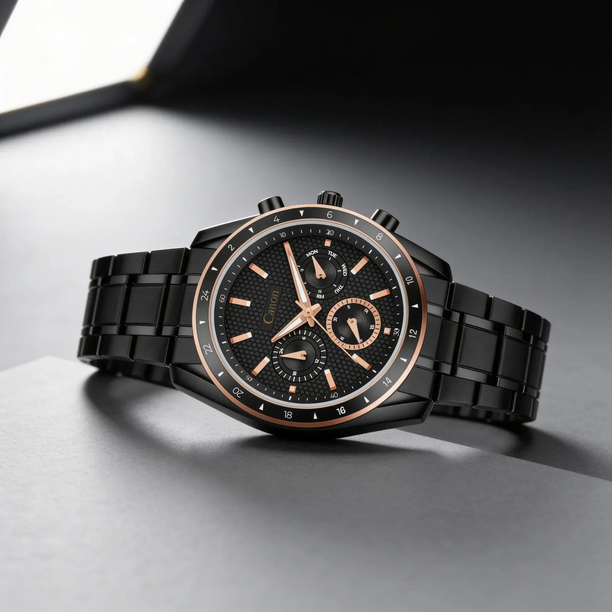 Black and rose gold analog watch with metal band on a modern gray background