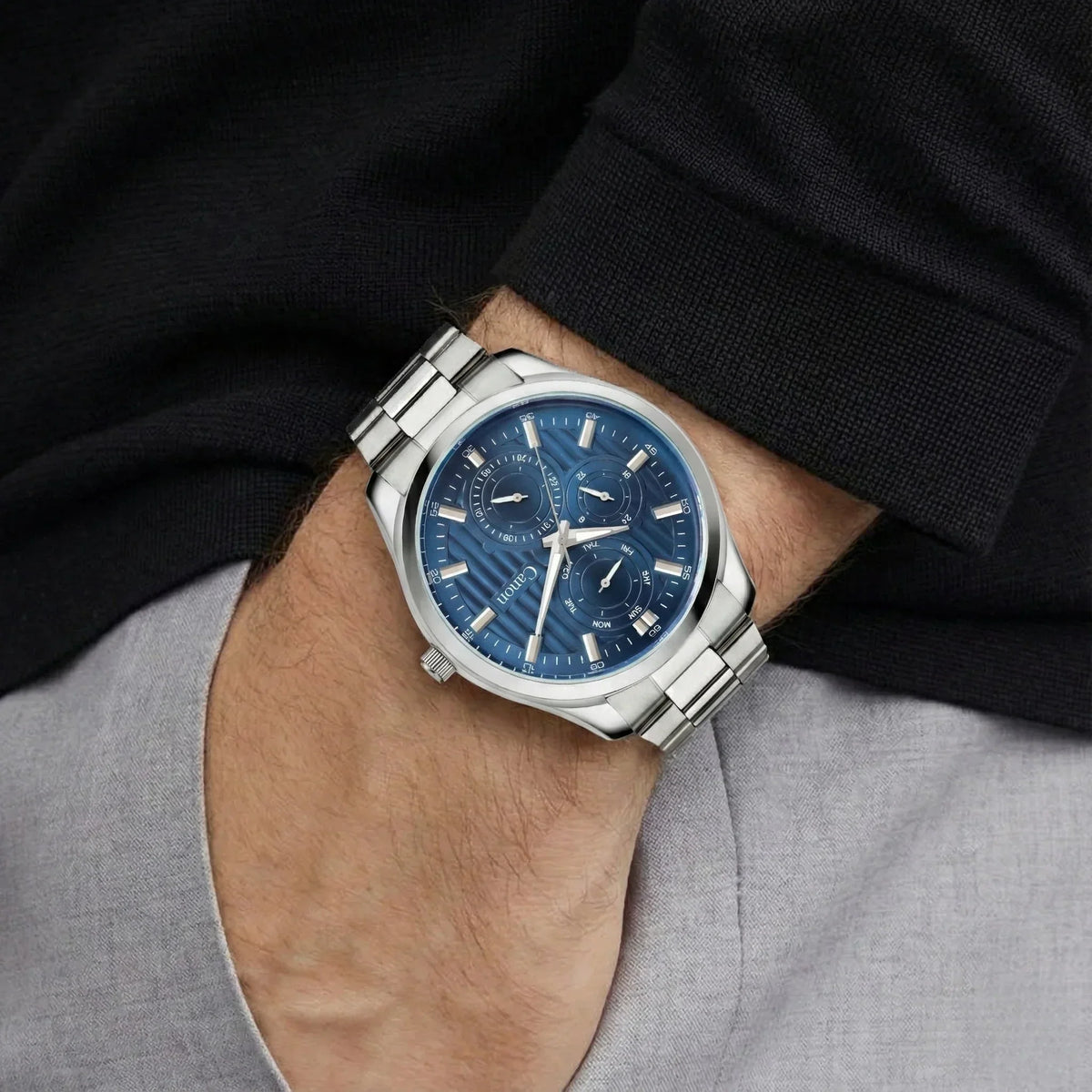 Men's silver analog watch with a blue dial and multi-function subdials on wrist