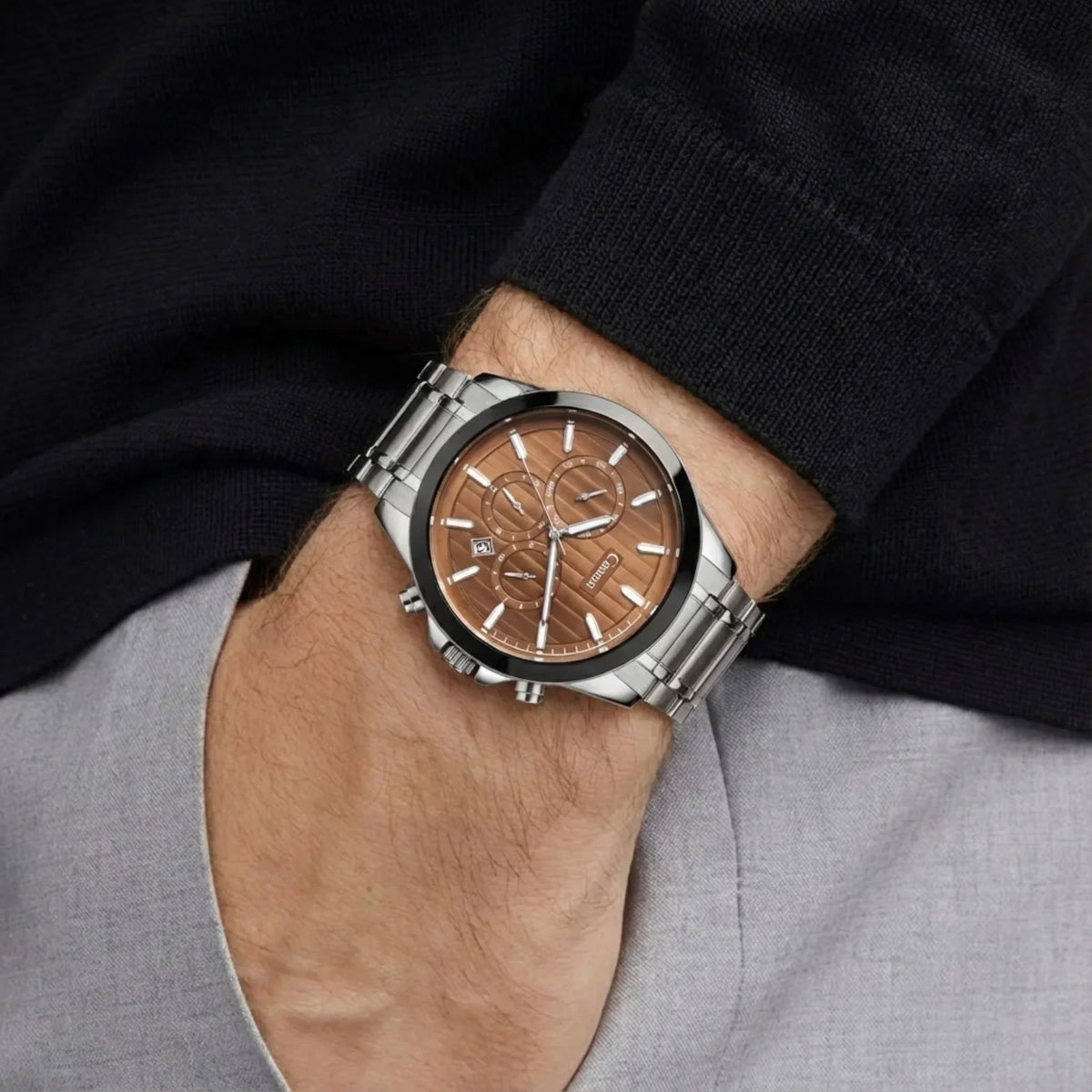 Men's analog watch with silver metal band and brown dial on wrist