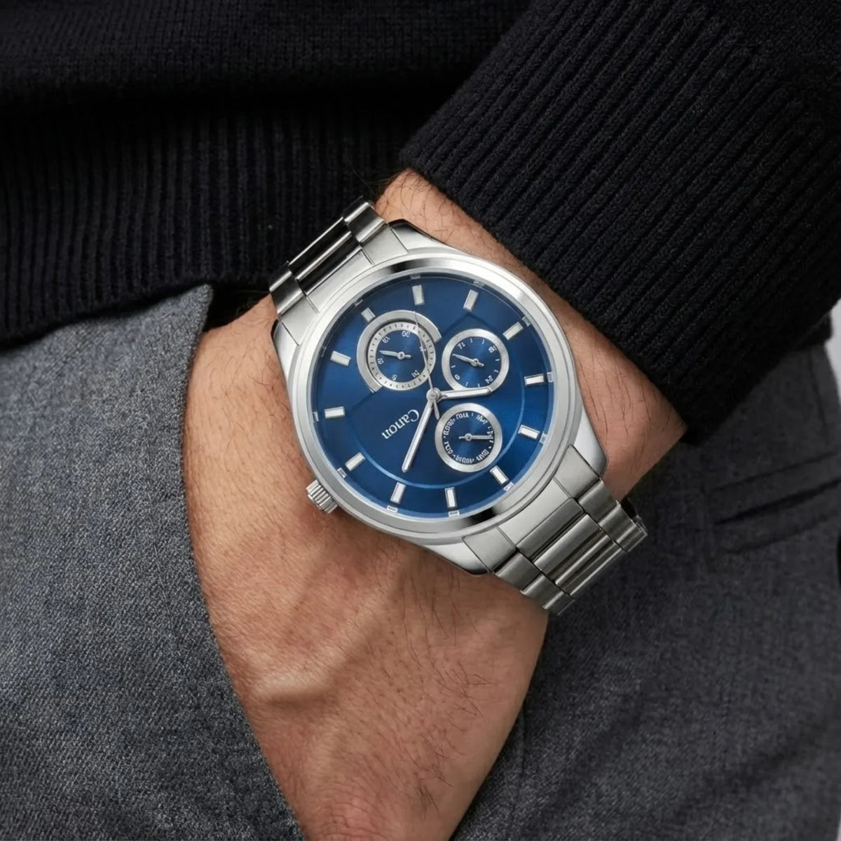 Men's silver analog wristwatch with blue dial and subdials on wrist, classic style