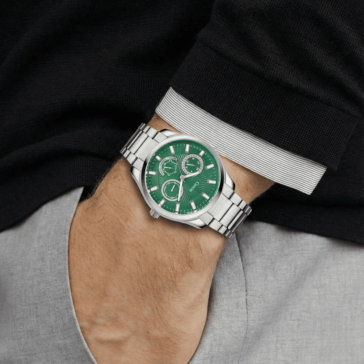 Men’s analog watch with green dial and silver metal strap worn on wrist