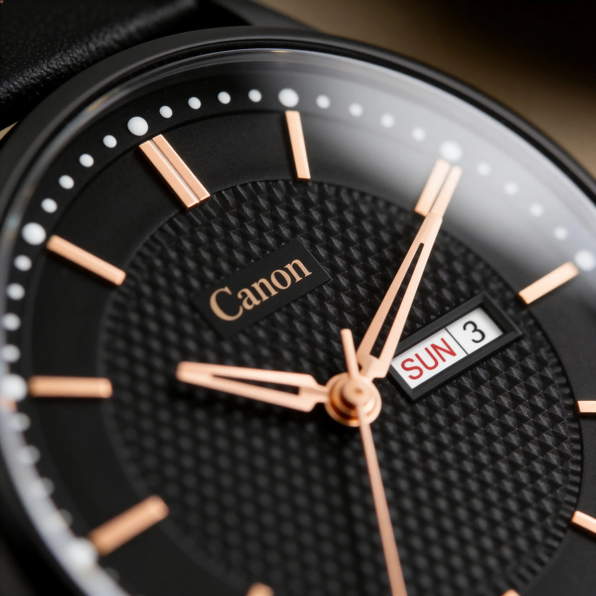 Black analog watch with gold markers and hands, textured dial, and day-date display