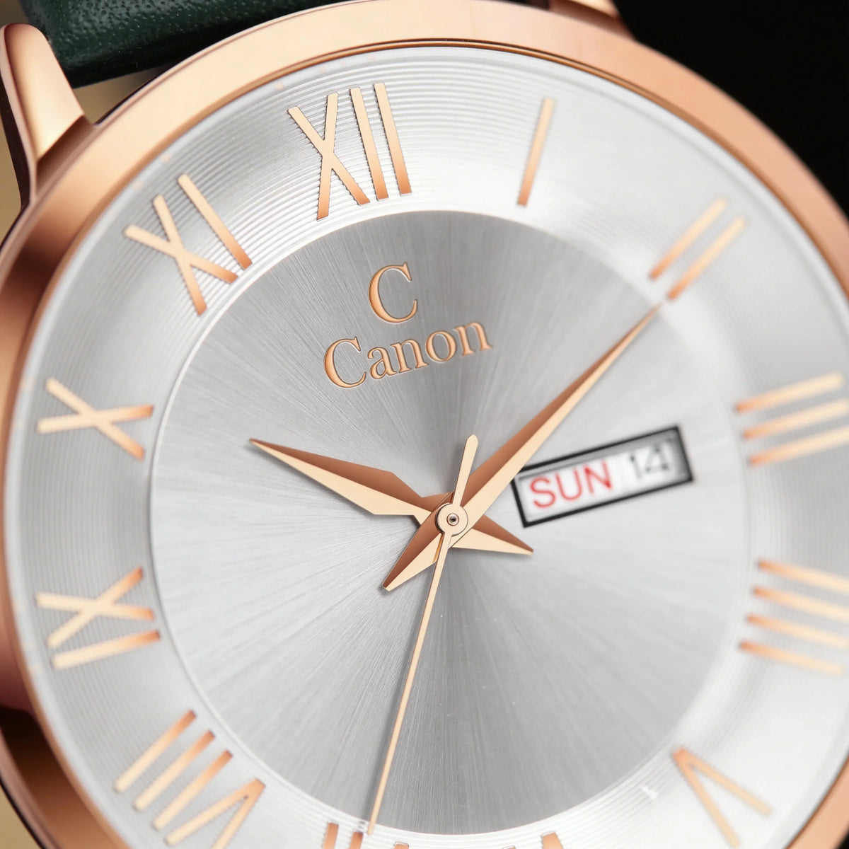 Close-up of an analog quartz watch with gold Roman numerals, day-date display, and silver dial.