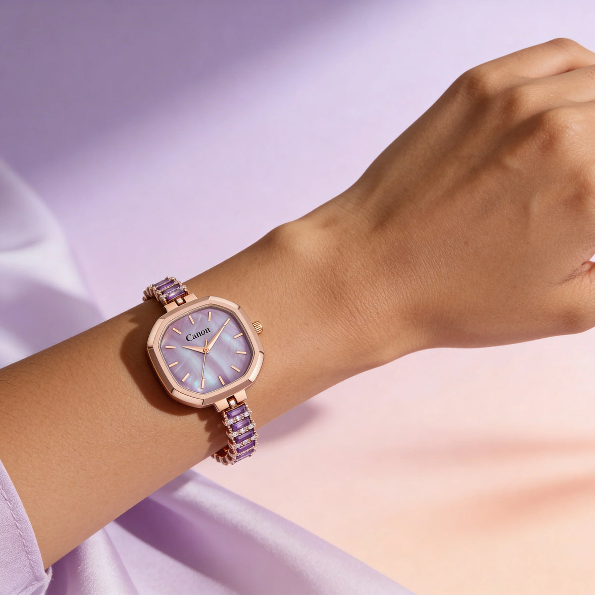 Rose gold women's analog watch with purple face and gemstone bracelet on wrist