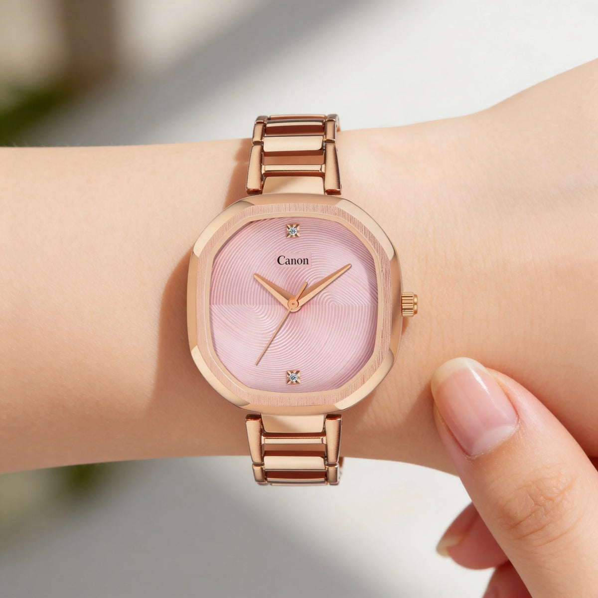 Elegant rose gold analog watch with pink square dial on woman's wrist
