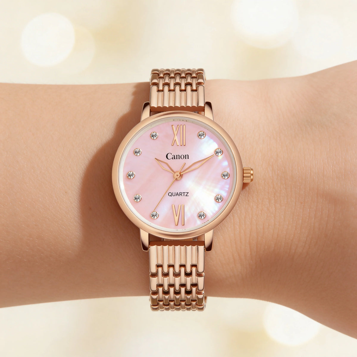 Rose gold analog wristwatch with pink mother-of-pearl dial and crystal hour markers on wrist