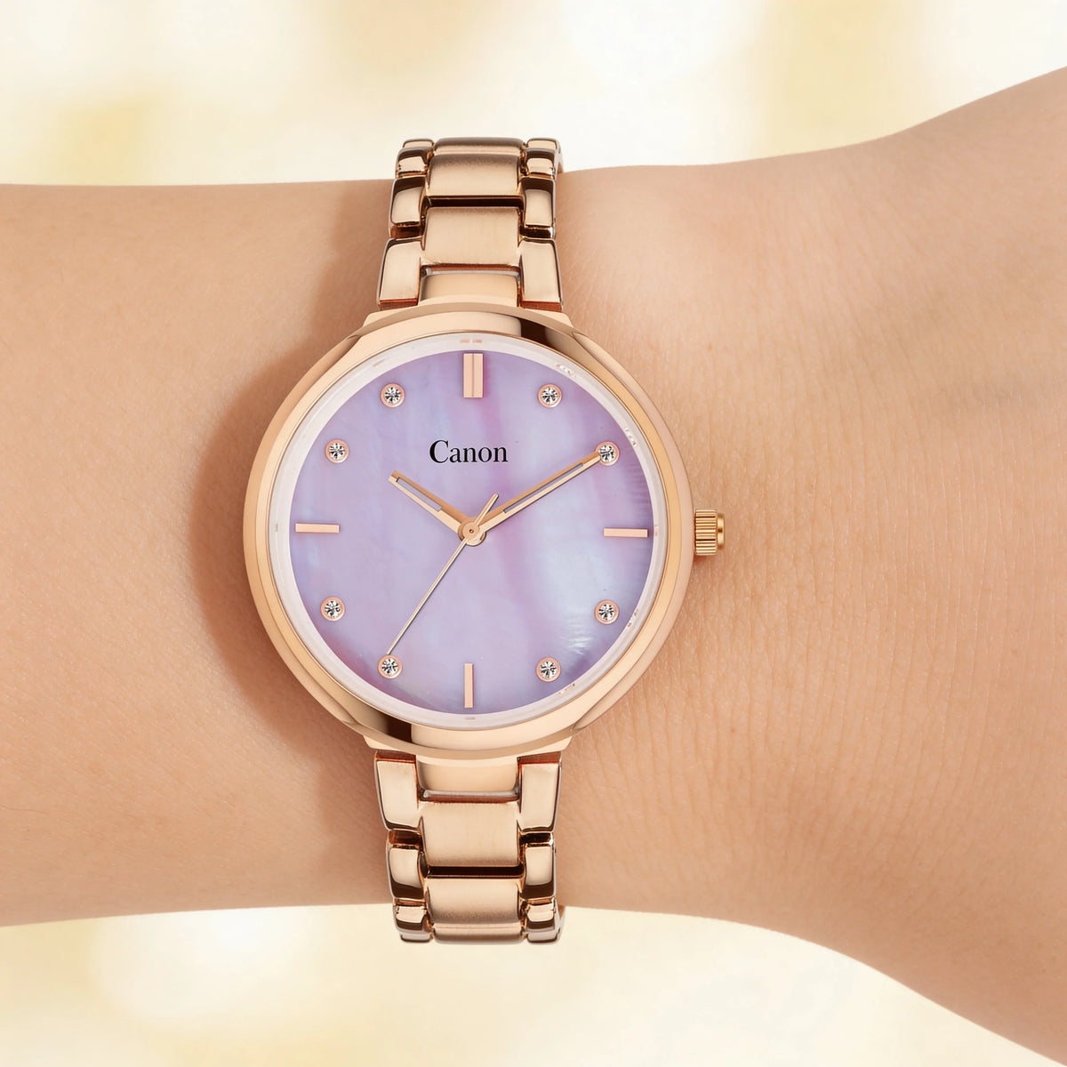 Rose gold analog watch with purple mother-of-pearl dial on wrist, women's classic style