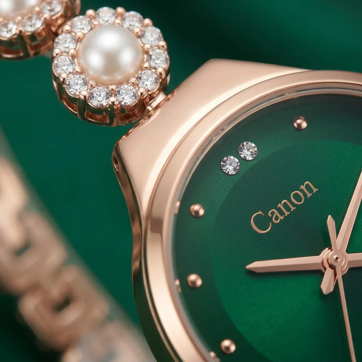 Elegant rose gold watch with green dial, crystal accents, and pearl detail on crown