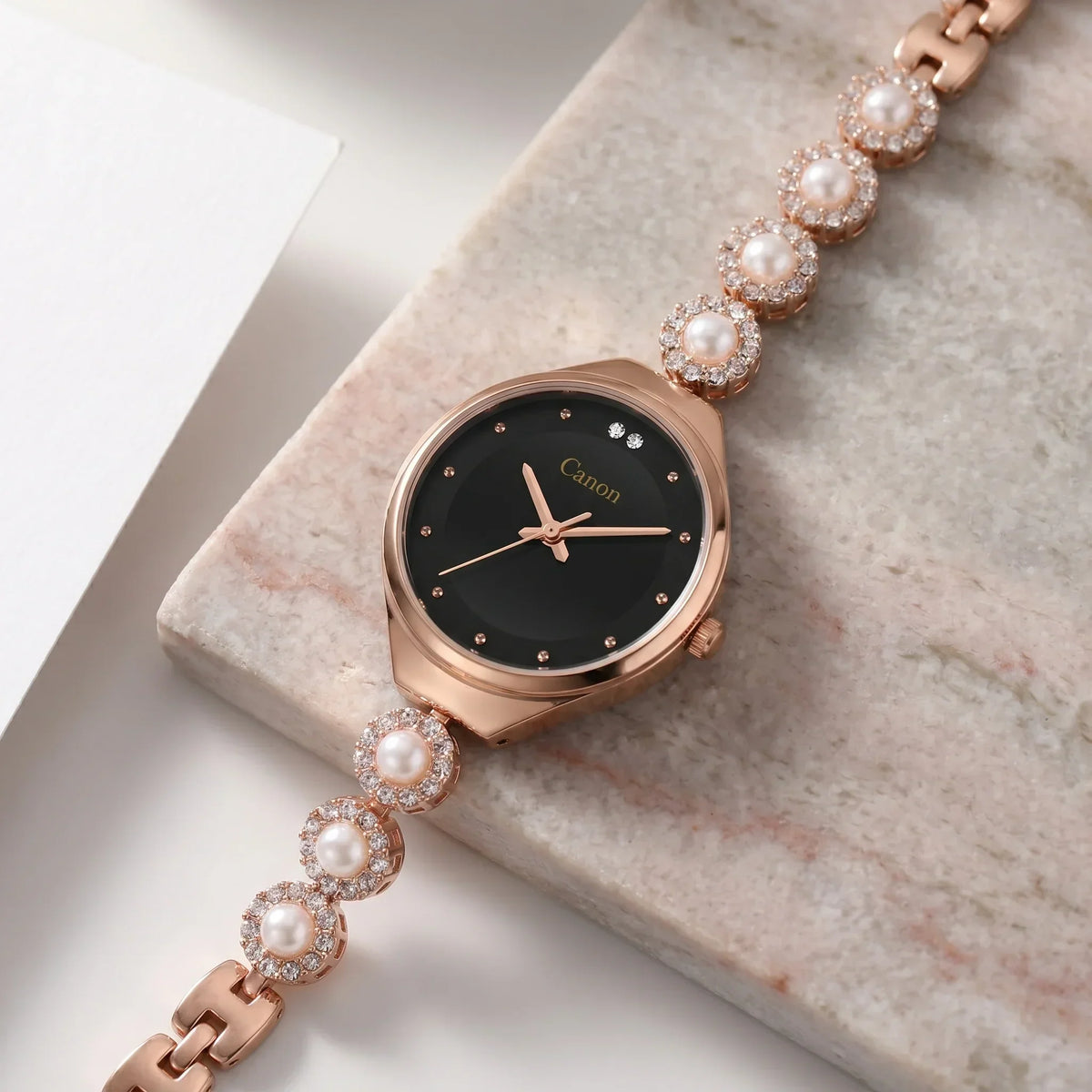 Elegant rose gold watch with black dial, pearl & crystal accents on marble, for women