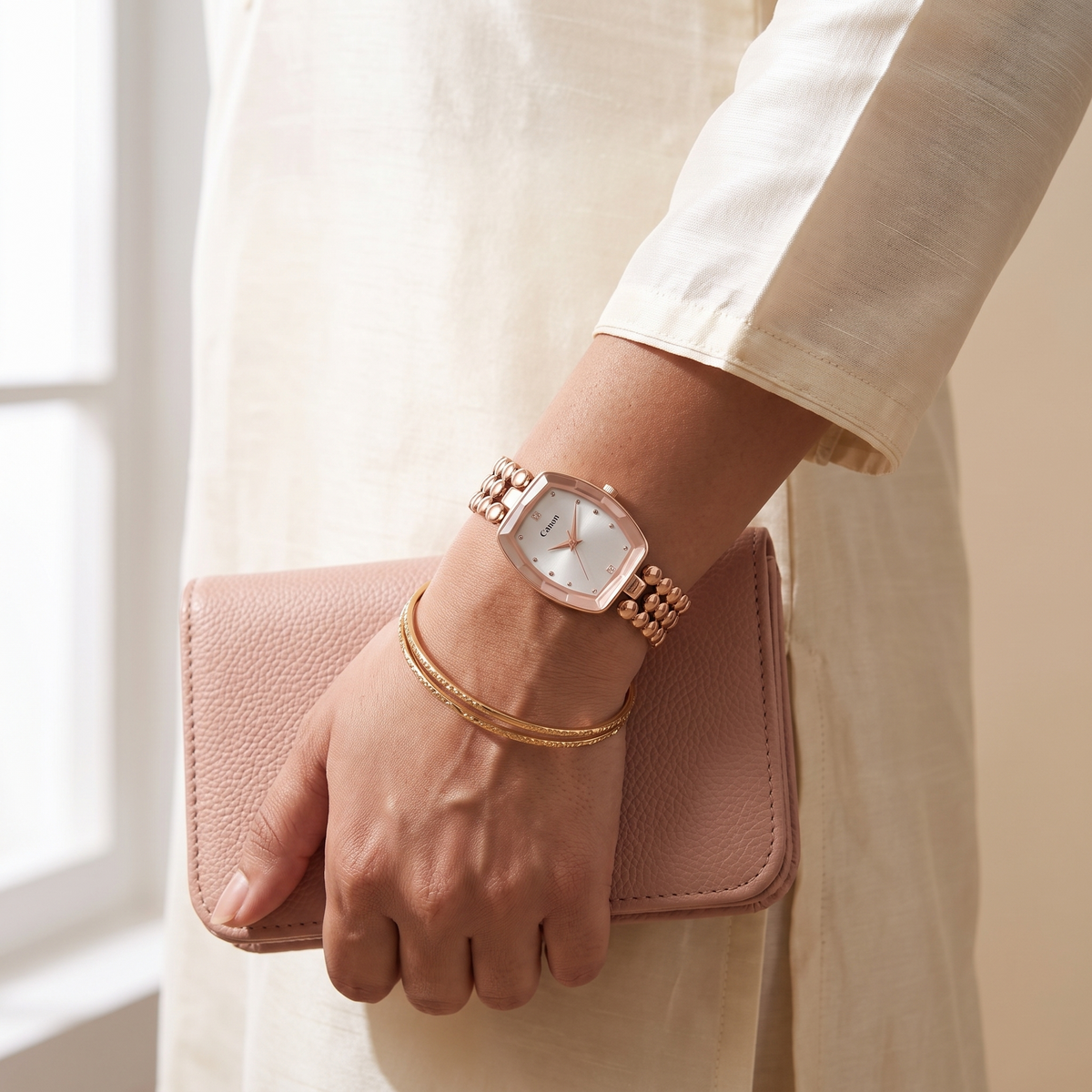 Woman in ivory kurta wearing CN-524 rose gold watch holding a pink clutch