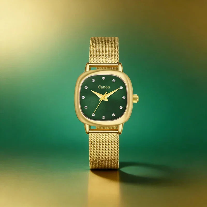 Gold analog watch with green dial and crystal hour markers on a gold mesh strap