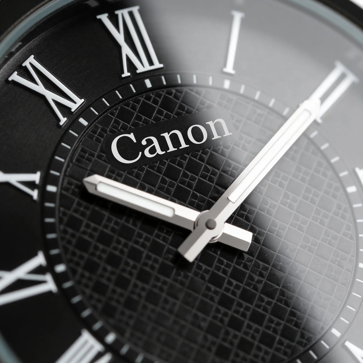 Canon analog watch with black dial, Roman numerals, and textured pattern for men and women