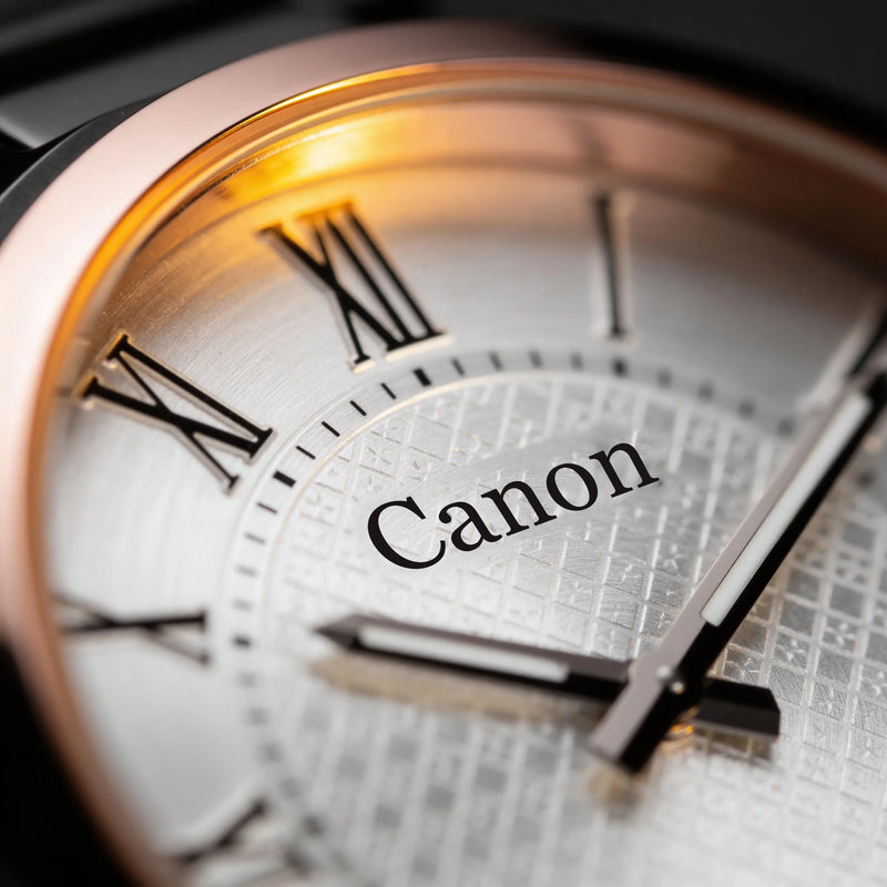 Close-up of a Canon analog watch face with Roman numerals, textured dial, and rose gold bezel.