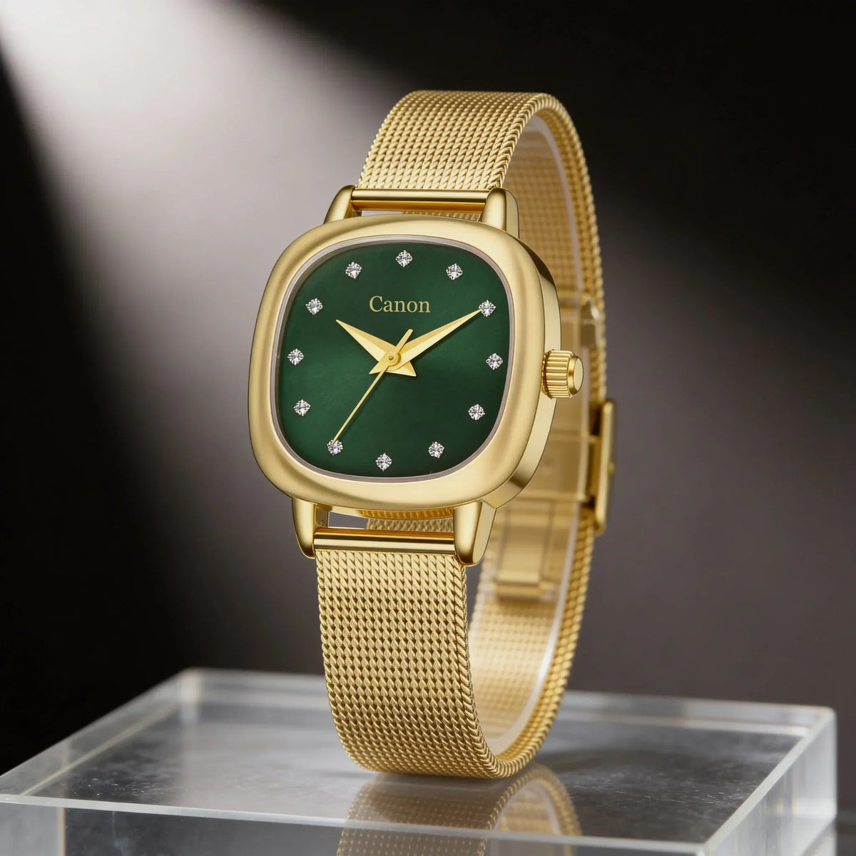 Elegant gold watch with green dial and diamond markers, displayed on clear stand
