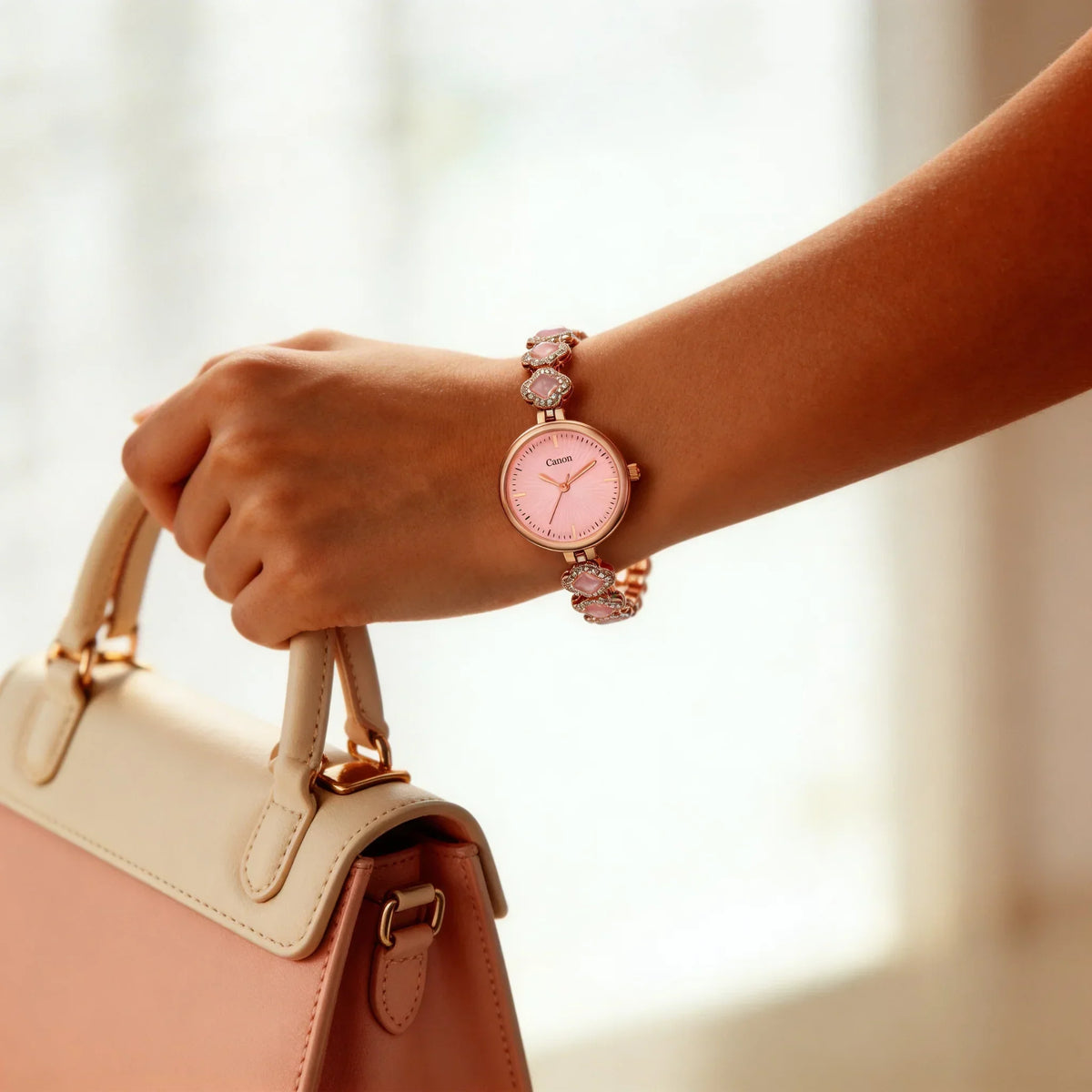 Elegant women's analog watch with pink dial and gemstone bracelet, worn on wrist, holding purse
