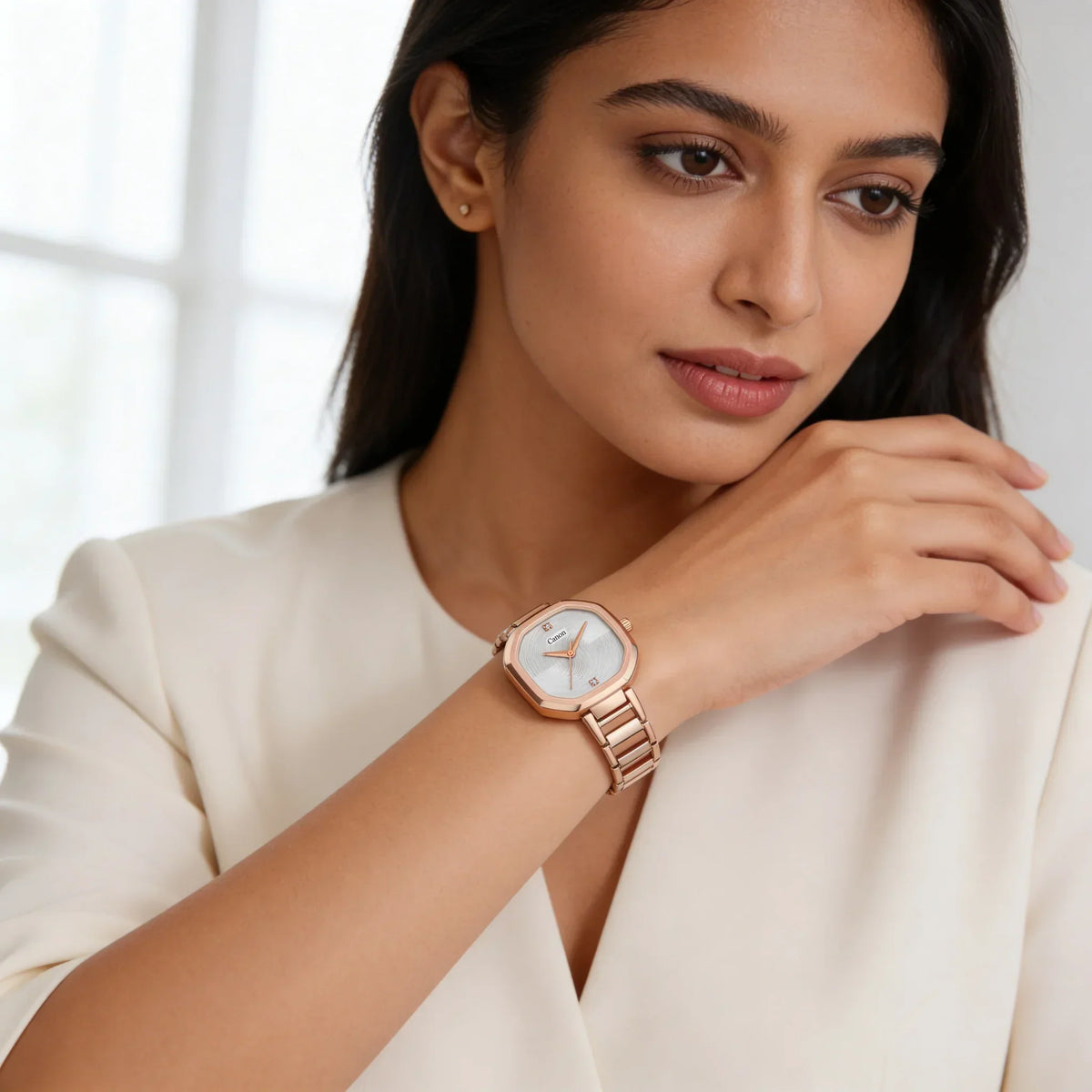 Woman wearing elegant rose gold analog wristwatch with hexagonal face and white dial