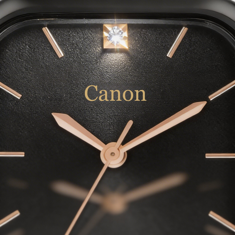 Close-up of a black analog watch face with gold hands and hour markers, gemstone at twelve.