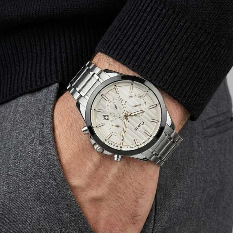 Silver watch on a wrist with a dark sweater and gray pants