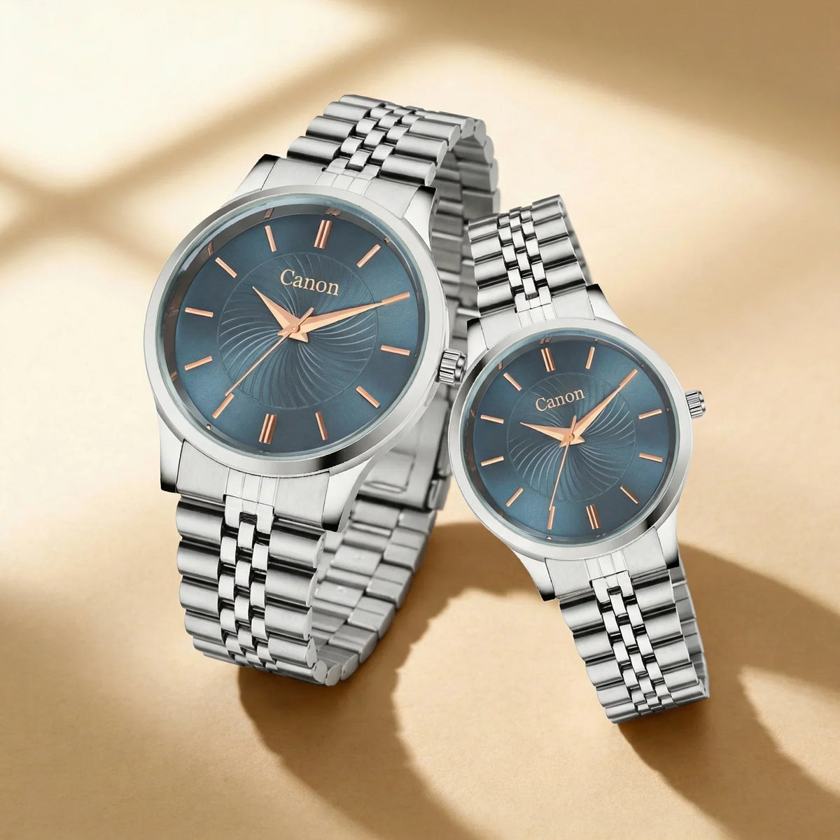 Pair of silver analog watches with blue dials and metal bands on beige background