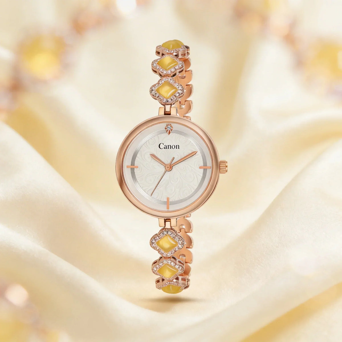 Elegant women's rose gold analog watch with yellow gemstone accents on a silky background