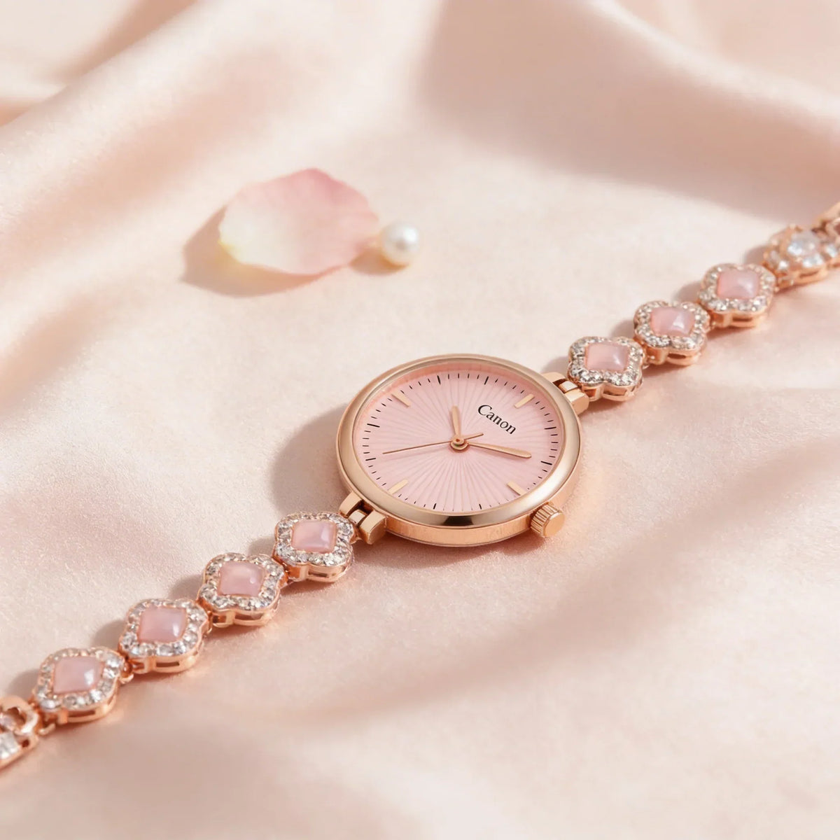 Elegant women's rose gold analog watch with pink dial and crystal bracelet on satin fabric