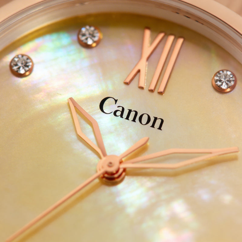 Close-up of an analog watch with gold hands, mother-of-pearl dial, and crystal hour markers