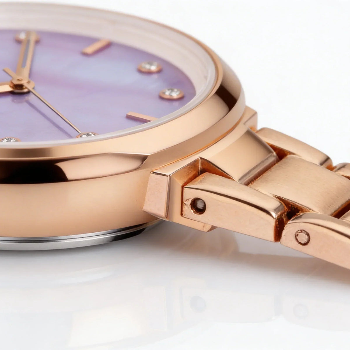 Rose gold analog watch with purple face and crystal hour markers on metal link band