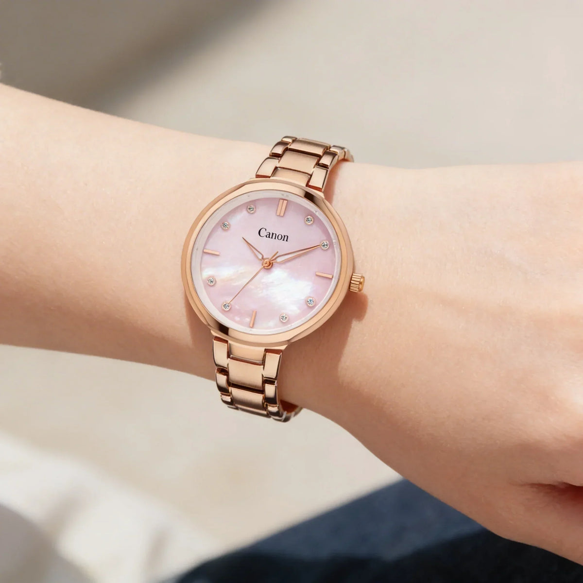 Rose gold analog watch with pink mother of pearl dial on wrist, elegant women's style