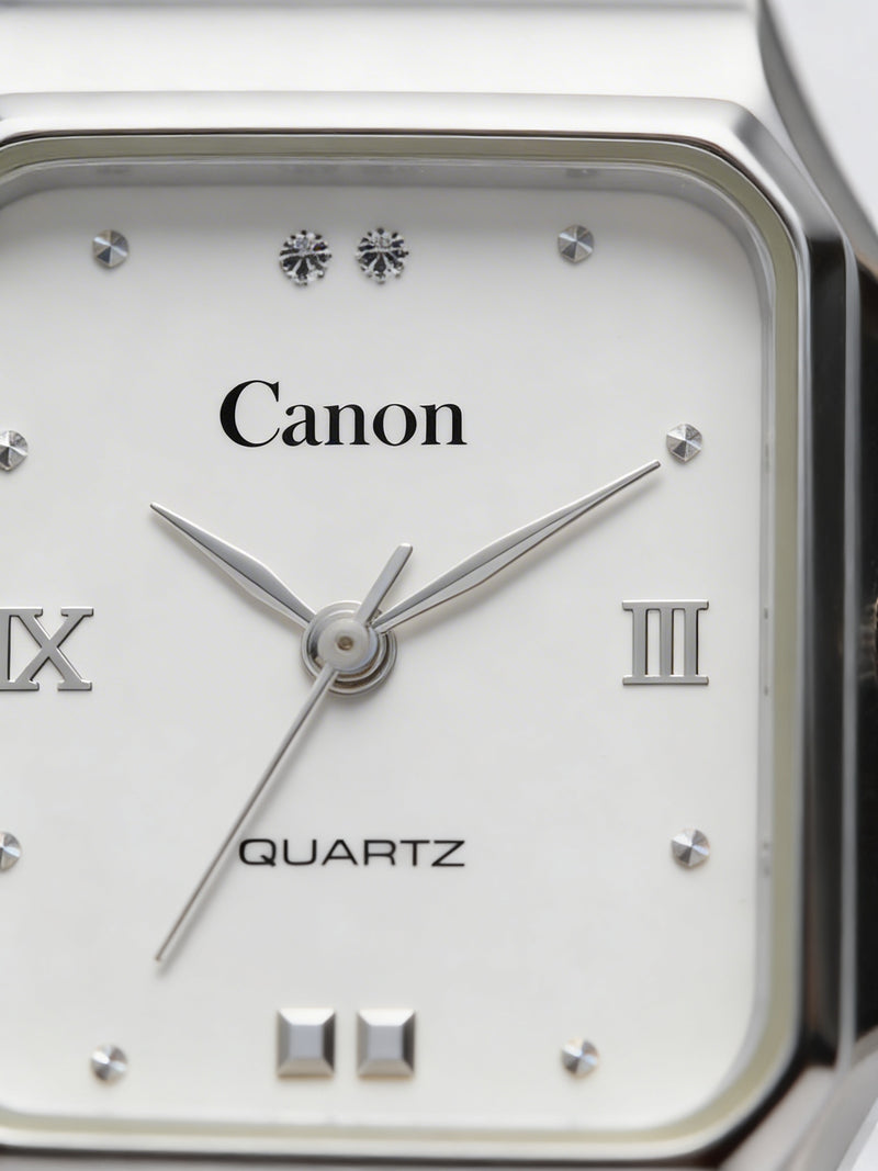Close-up of a silver analog quartz watch with a white square face and Roman numerals.