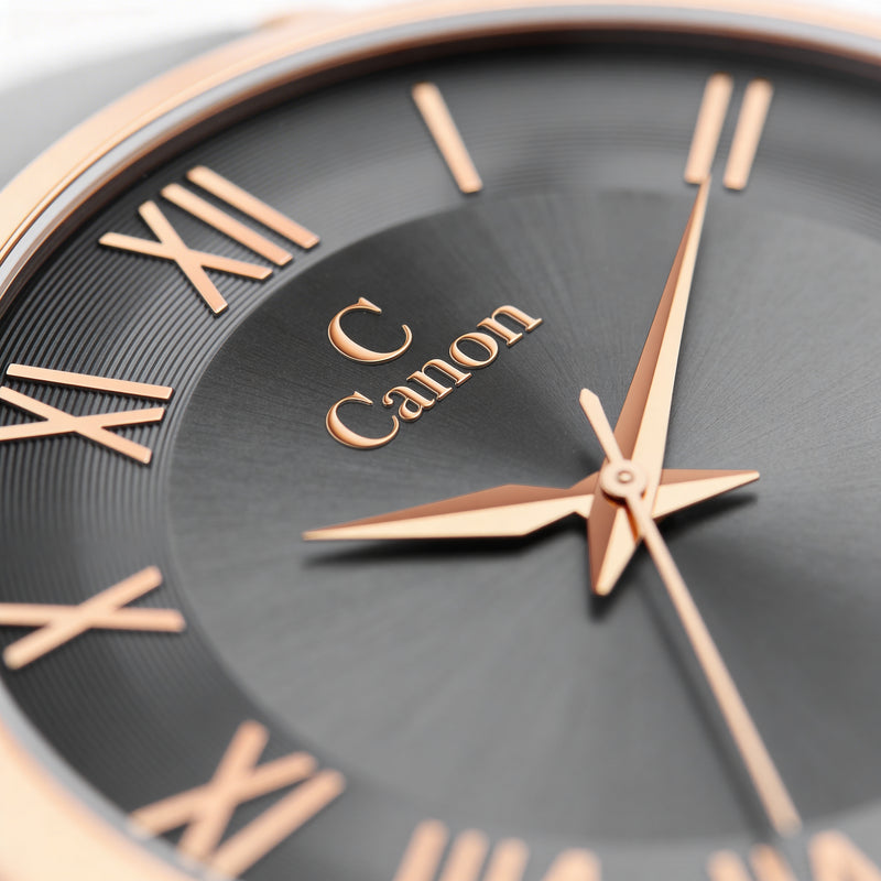 Close-up of a black analog watch face with gold Roman numerals and hands