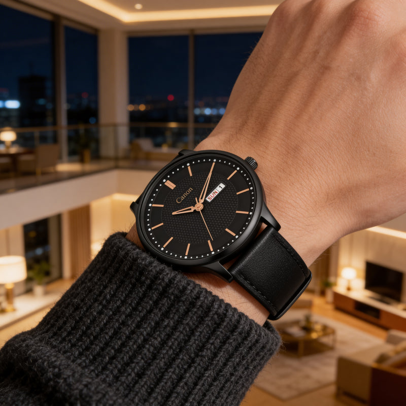 Black analog men's watch with gold markers and date display on wrist in modern living room