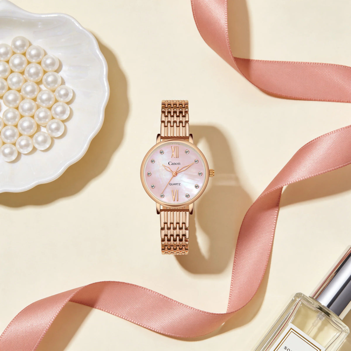 Elegant rose gold women's analog quartz watch with pink face, pearls, and ribbon accent