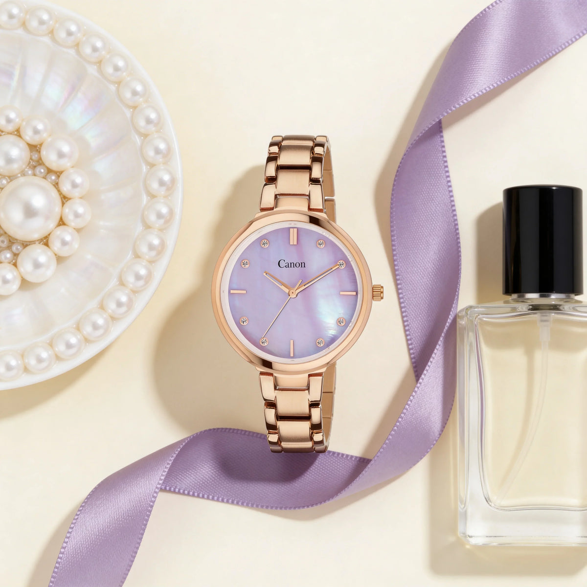 Rose gold analog watch with purple mother of pearl dial, pearls, and perfume on cream background