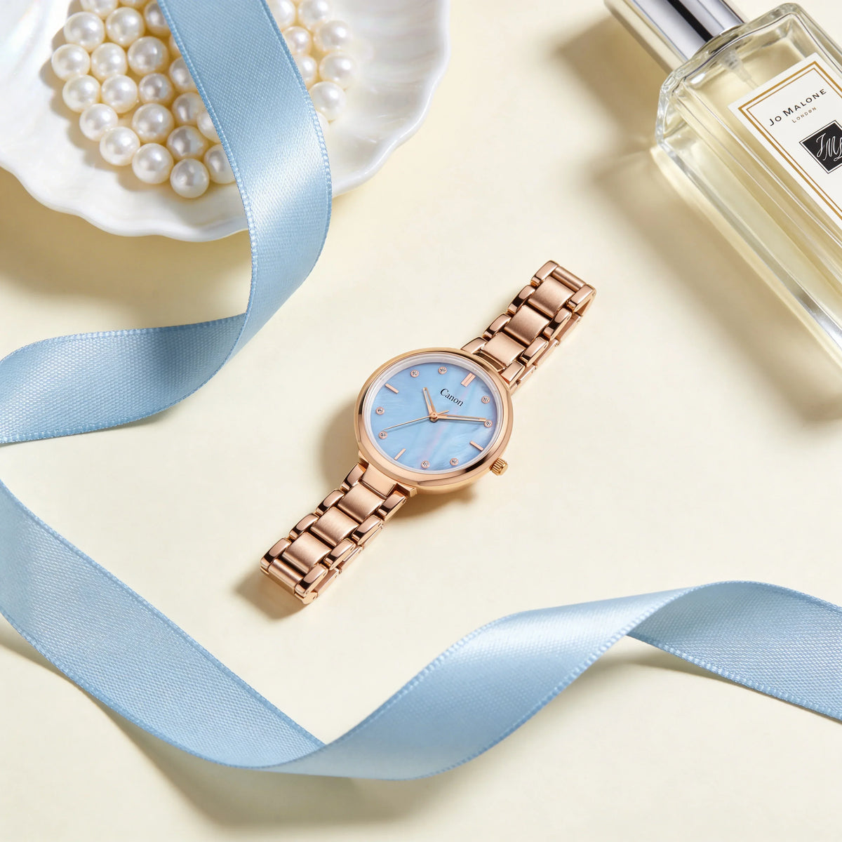 Elegant rose gold analog watch with blue dial, luxury accessories, and light blue ribbon