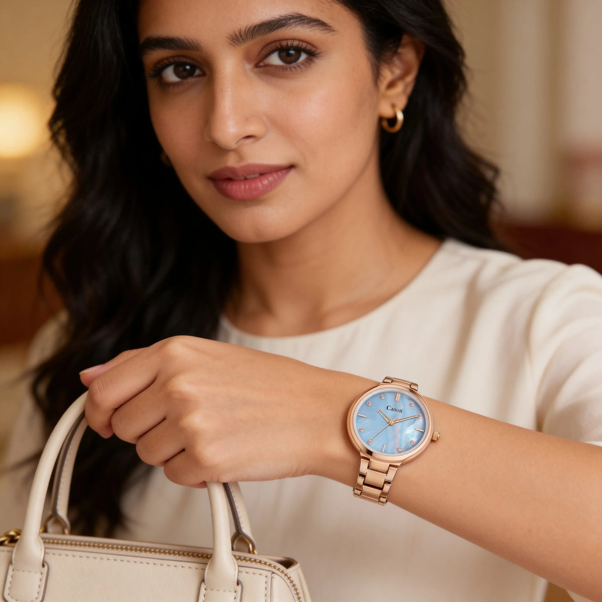Woman wearing elegant rose gold analog watch with blue dial, holding beige purse