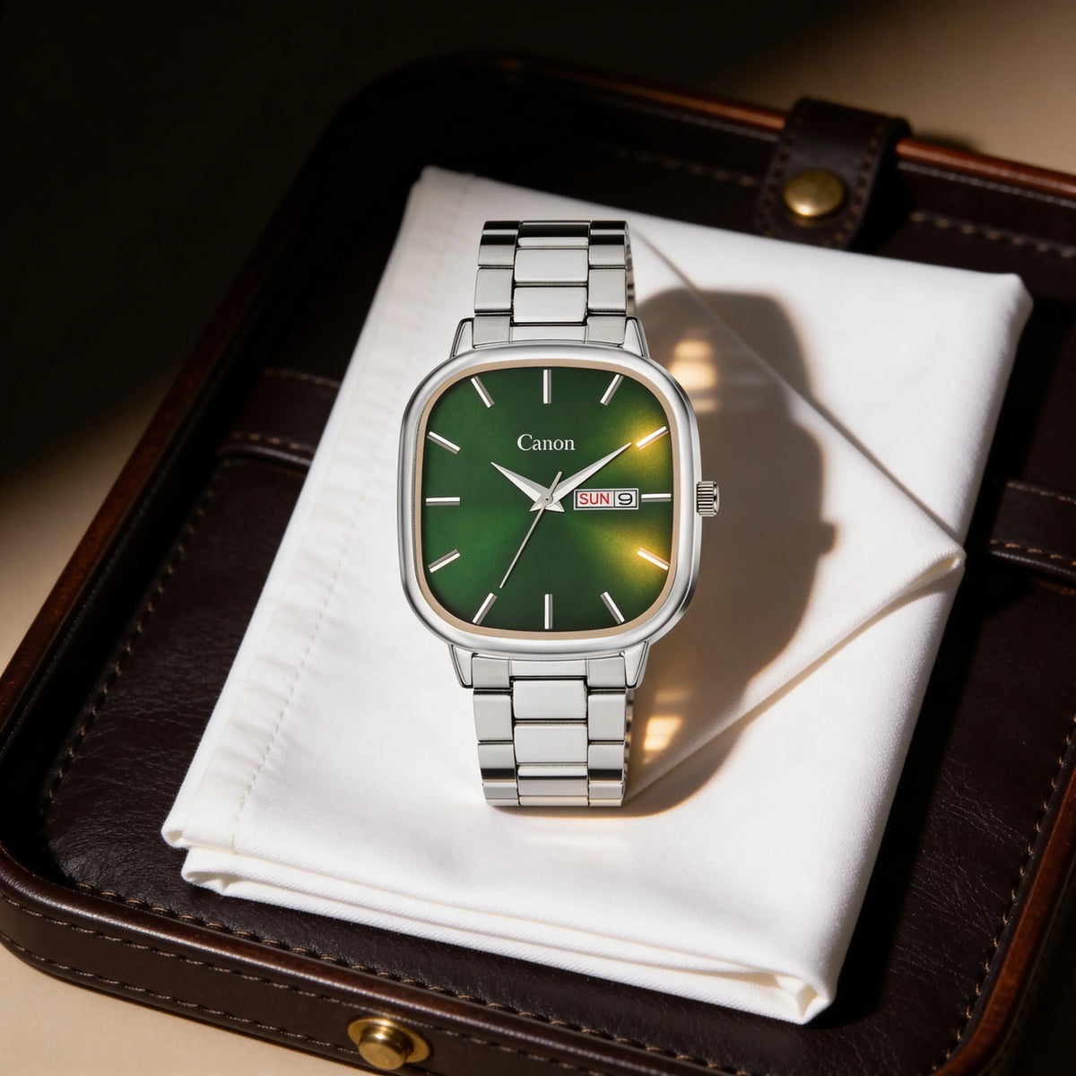 Men's silver analog watch with green face and day-date display on white cloth and leather case