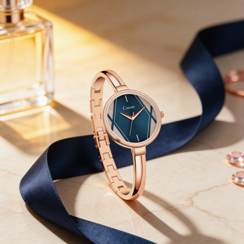 Elegant women's rose gold analog watch with blue dial on marble, luxury ribbon and perfume bottle background