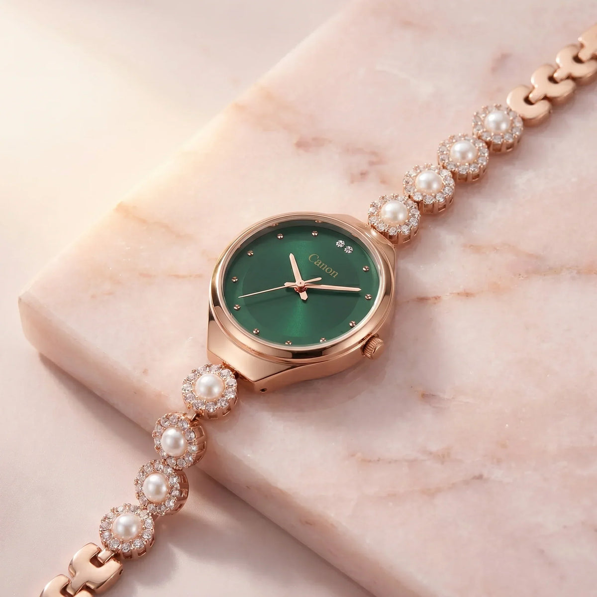 Elegant rose gold watch with green dial, pearl & crystal accents on marble, perfect for women's fashion.