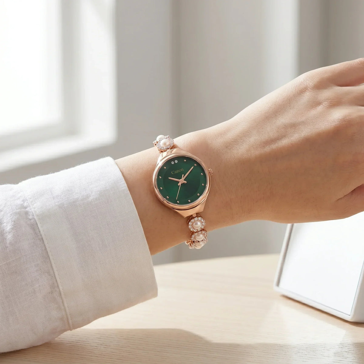 Elegant women's analog watch with green dial, rose gold case, pearl & crystal bracelet, worn on wrist