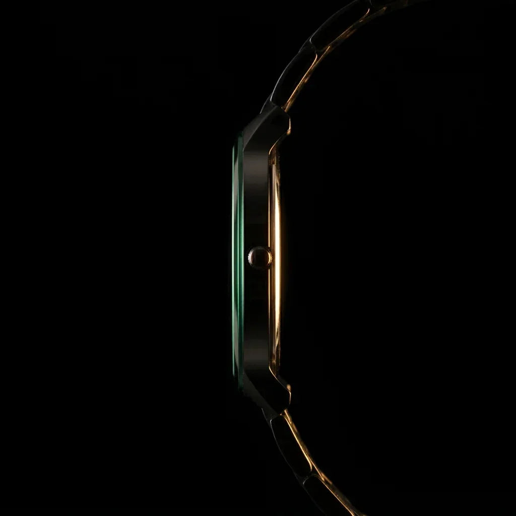Elegant gold-tone analog watch with sleek design and green accent, showcasing timeless style
