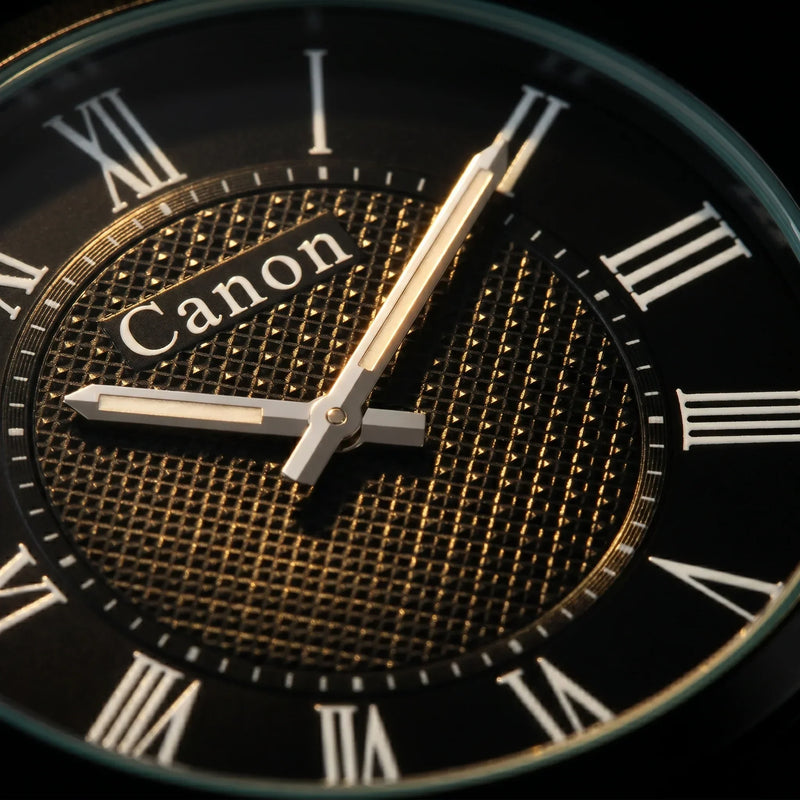 Canon analog watch with black dial, Roman numerals, and gold textured center