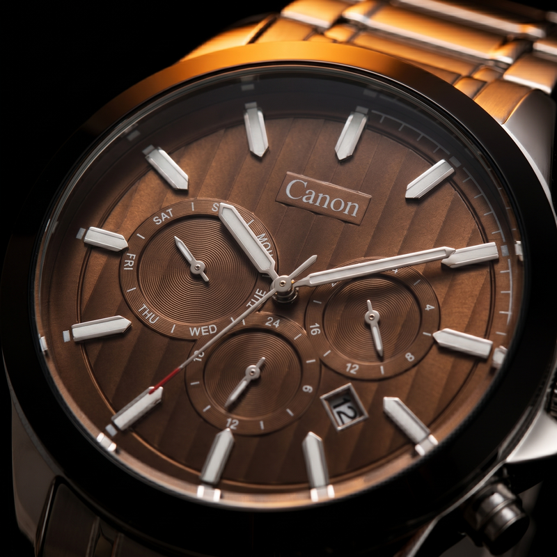 Canon men's analog quartz watch with brown dial, day-date subdials, and stainless steel strap