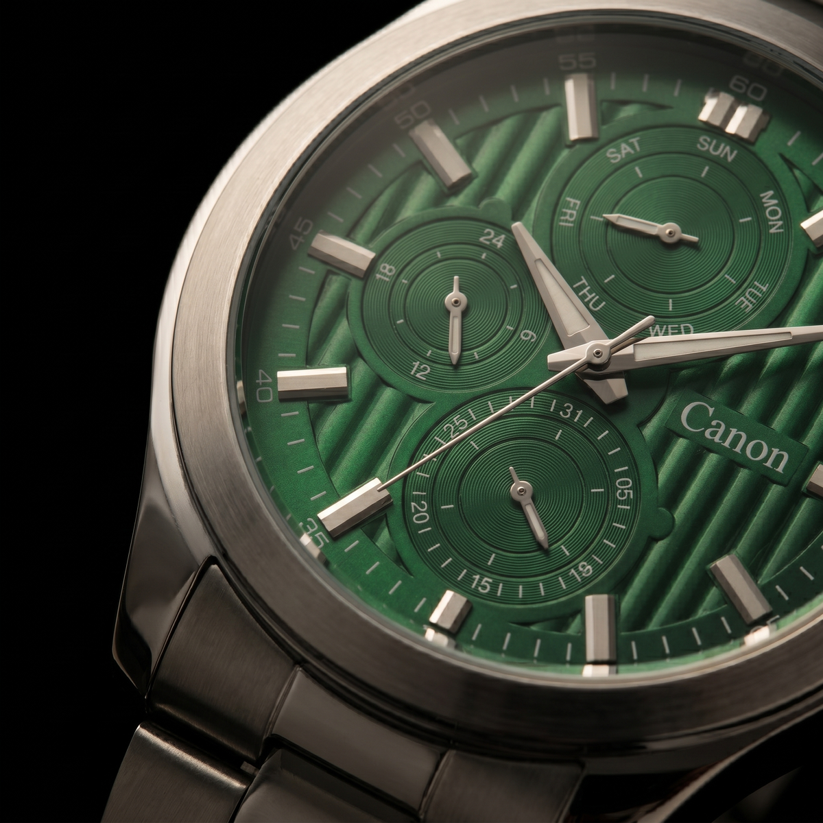 Green dial analog quartz watch with day-date subdials, silver-tone case and bracelet, Canon branding