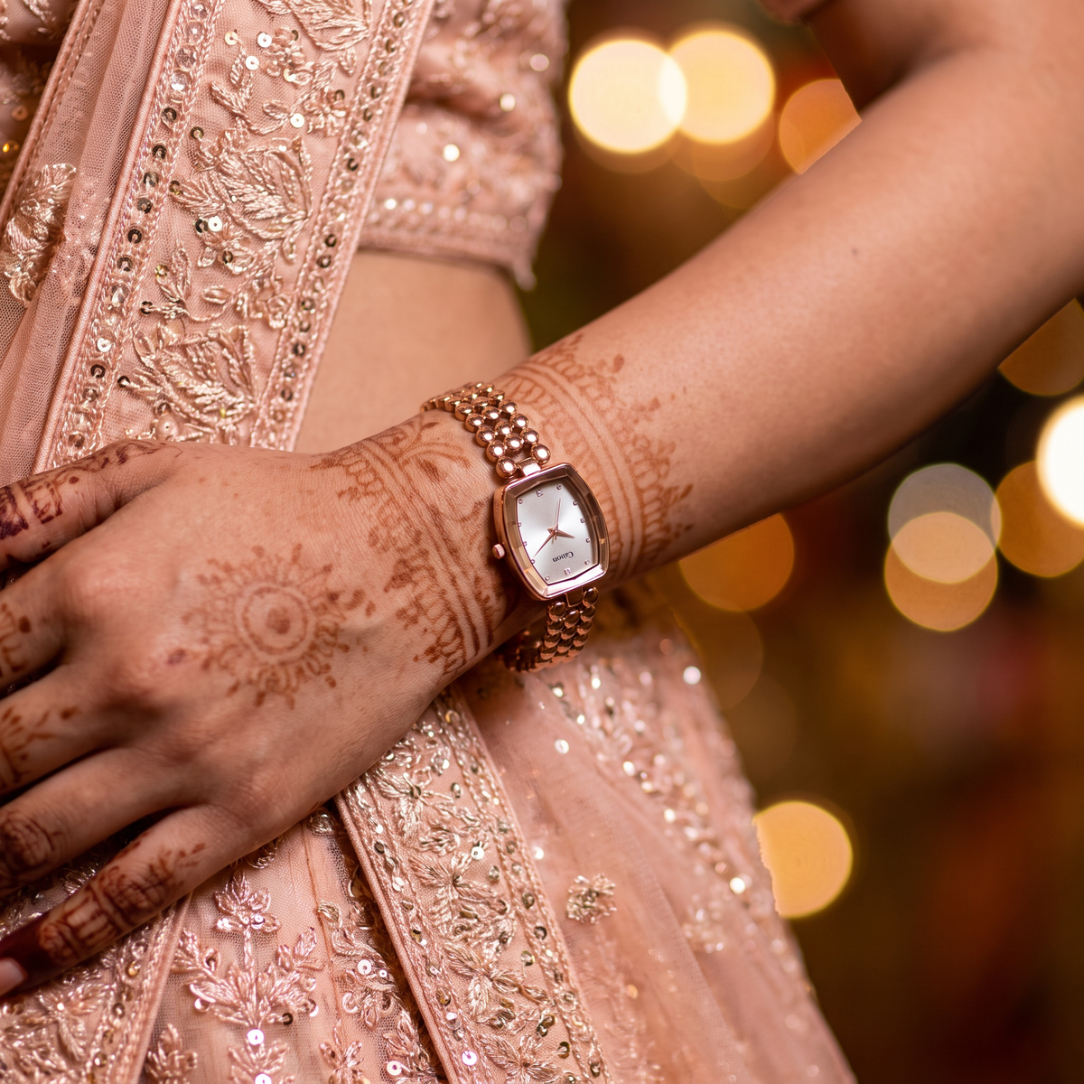 CN-524 rose gold watch worn with a pastel lehenga and mehndi at a wedding