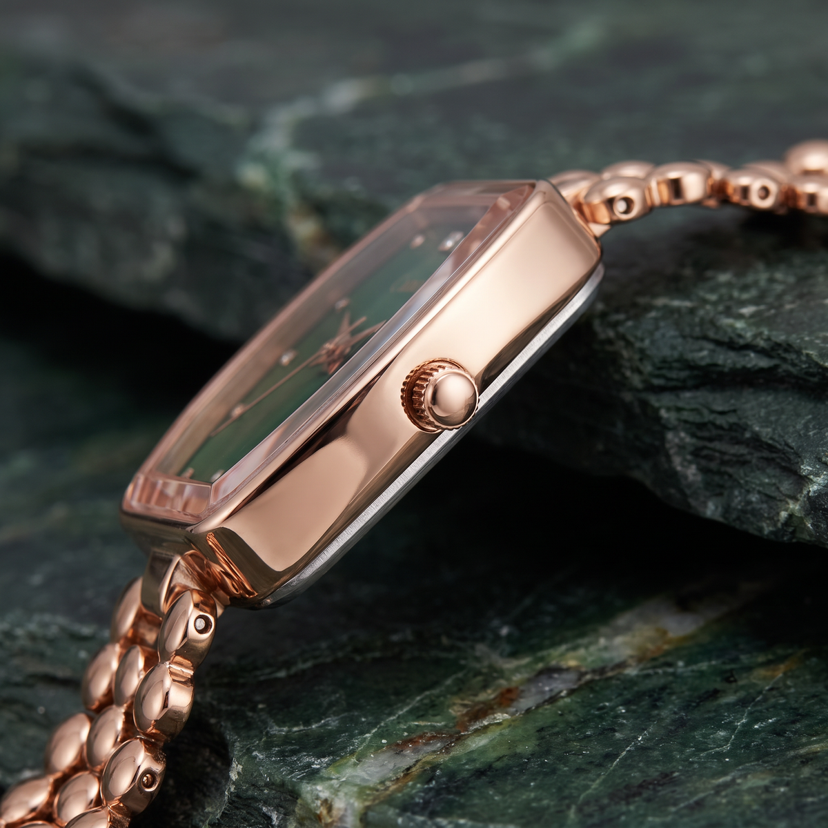 Side profile macro of CN-525 rose gold case and crown on green stone